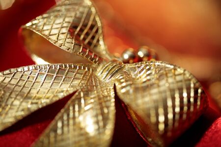 golden  bow close-up on red holiday backgroundの写真素材