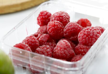 fresh raspberries fruit in plastic container close-upの写真素材