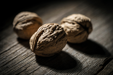 Three walnuts close-up on wooden backgroundの写真素材