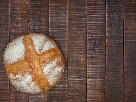 Bread and salt on a wooden table. Prepared according to the classic recipe in the oven.の写真素材