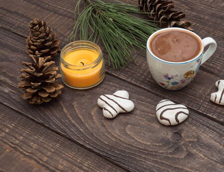 Freshly brewed cocoa with foam and white gingerbread on a wooden tableの写真素材