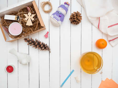 Large glass cup of green tea and a ripe tangerine on an old wooden table painted whiteの写真素材