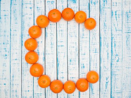 Juicy mandarins are laid out on a wooden tableの写真素材