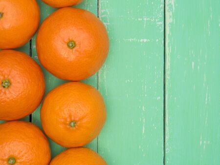 Juicy mandarins are laid out on a wooden tableの写真素材