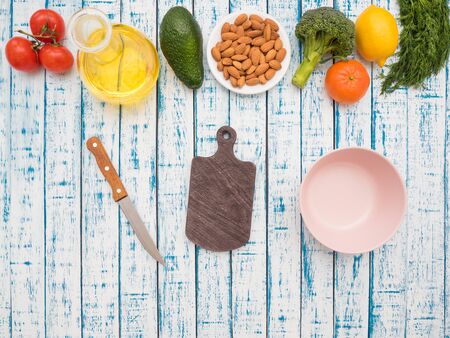 Sunflower oil in a decanter, tomatoes, avocado, dill, mandarin and lemon on a wooden tableの写真素材