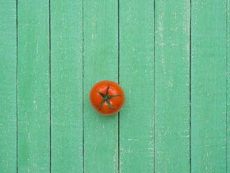 Fresh red tomato lies on a wooden tableの写真素材