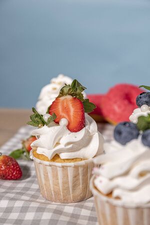 Candy bar. Cupcakes with blueberries strawberries and mint. Donuts in green and pink glaze with sprinkles.の写真素材