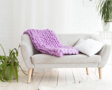 Large knitted merino wool blanket on the sofaの写真素材