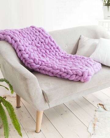 Large knitted merino wool blanket on the sofaの写真素材