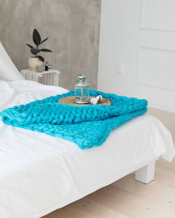 candlestick in the form of a lamp on a turquoise plaid of merino woolの写真素材