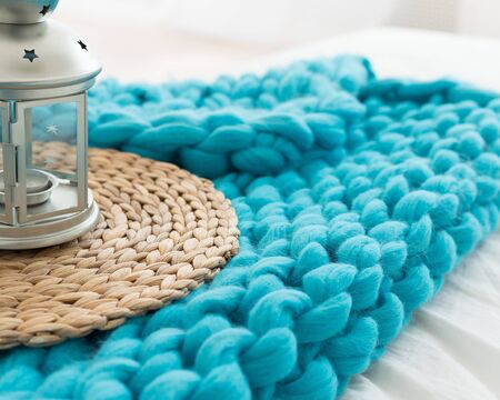 candlestick in the form of a lamp on a turquoise plaid of merino woolの写真素材