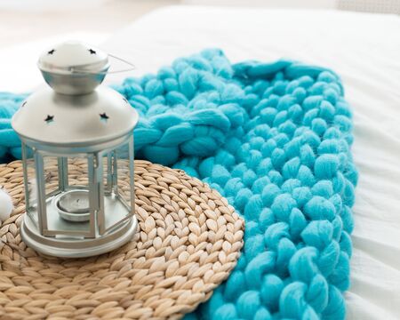 candlestick in the form of a lamp on a turquoise plaid of merino woolの写真素材