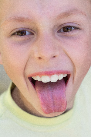 The Ukrainian boy laughs, shows the tongue and teeth on the cameraの写真素材