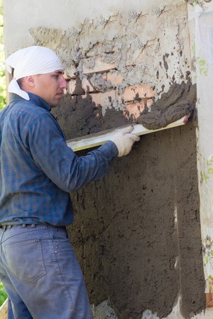 In Ukraine, most people plaster walls with their hands without automatic machinesの写真素材