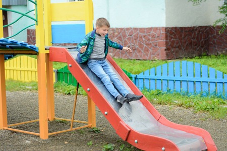 Beautiful Ukrainian boys run on a playground and descend from the hillsの写真素材