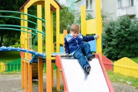 Beautiful Ukrainian boys run on a playground and descend from the hillsの写真素材