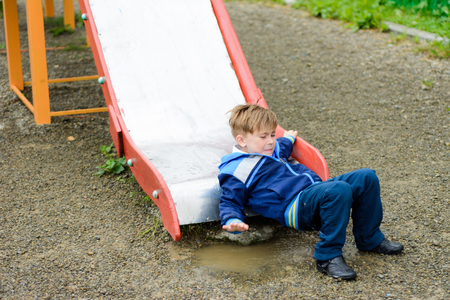 Beautiful Ukrainian boys run on a playground and descend from the hillsの写真素材