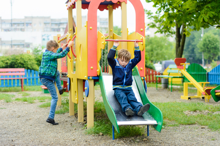 Beautiful Ukrainian boys run on a playground and descend from the hillsの写真素材