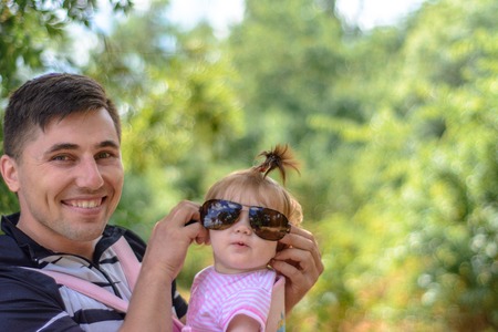 Amazing little girl is playing with sunglasses with her fatherの写真素材