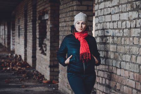 Beautiful young woman standing in a destroyed building in cold drowningの写真素材