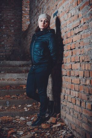 Beautiful young woman standing in a destroyed building in cold drowningの写真素材