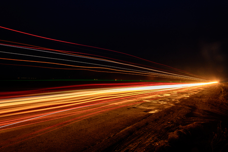 Photos of Ukrainian roads under the evening sky, on which cars are moving and blurring the way with their lightの写真素材