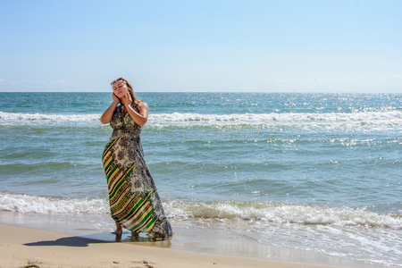 Photos of a wonderful woman in a beautiful dress that is resting on a Ukrainian beach in the Black Seaの写真素材