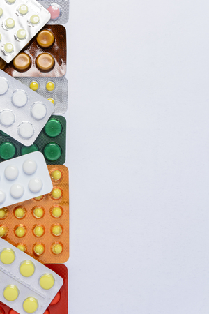 Packing of tablets of different colors on a white background with a place for the inscriptionの写真素材