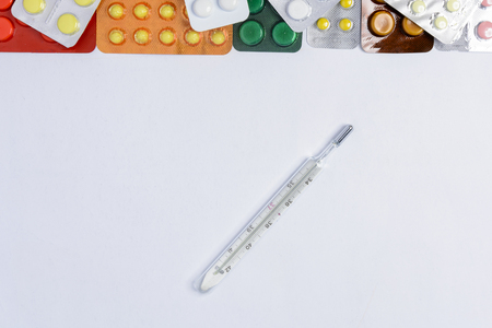 Photometer of a thermometer on a white background among tablets of different colors in packages of 2018の写真素材