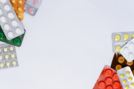 Packing of tablets of different colors on a white background with a place for the inscriptionの写真素材