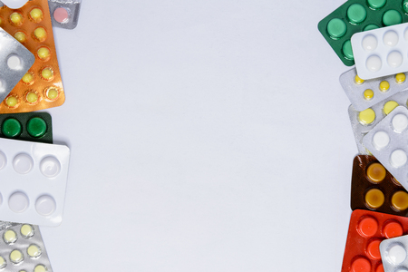 Packing of tablets of different colors on a white background with a place for the inscriptionの写真素材