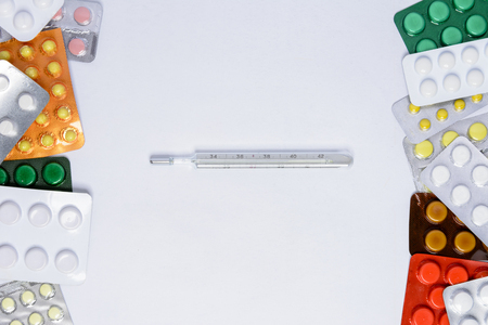 Photometer of a thermometer on a white background among tablets of different colors in packages of 2018の写真素材