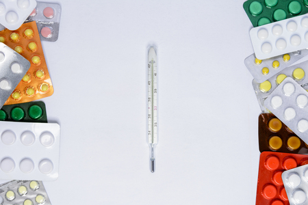 Photometer of a thermometer on a white background among tablets of different colors in packages of 2018の写真素材