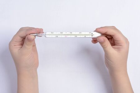 A teenager keeps the thermometer in order to check the body temperatureの写真素材