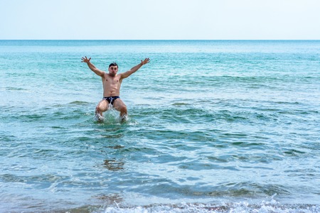 A sports man jumping over the sea waves in the black sea 2018の写真素材