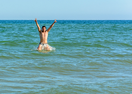A sports man jumping over the sea waves in the black sea 2018の写真素材