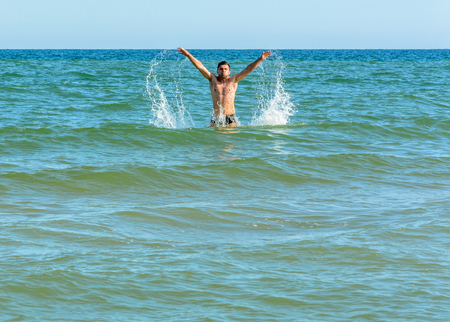 A sports man jumping over the sea waves in the black sea 2018の写真素材