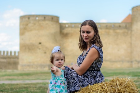 A young mother with her daughter sits on a strawの写真素材
