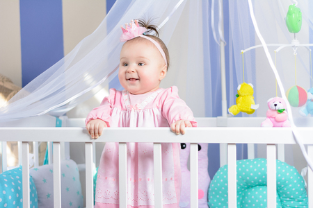 Cute toddler in her crib. Preparing for her midday nap.の写真素材
