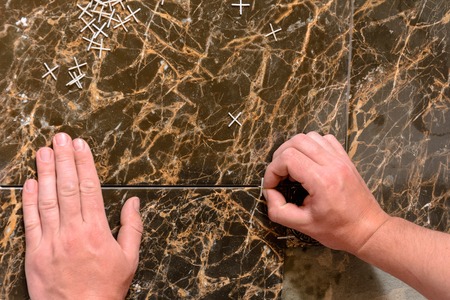 Plastic crosses for laying tiles on the floor are scattered over the tile