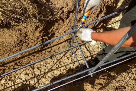 Reinforcement of concrete with metal rods connected by wire and wooden formworkの写真素材