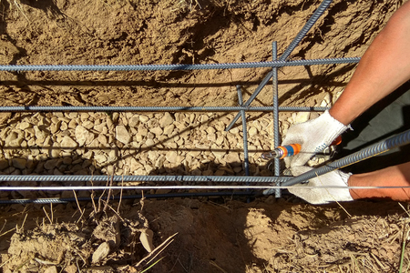 Reinforcement of concrete with metal rods connected by wire and wooden formworkの写真素材