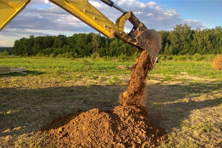 A work excavator digs a trench in a country houseの写真素材