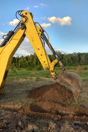 View from above at working excavator tractor digging a trench.の写真素材