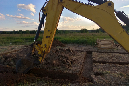 View from above at working excavator tractor digging a trench.の写真素材