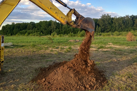 A work excavator digging a trench for the foundation of a buildingの写真素材