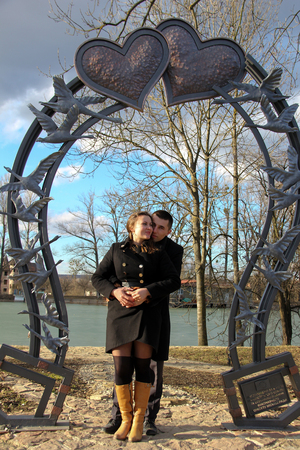 Loving couple in valentines day in a city park against a lake under a large forged heart 2018の写真素材