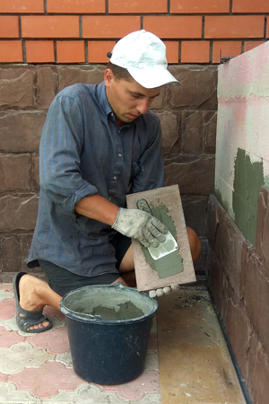 Professional worker gluing decorative tile on wall 2018の写真素材