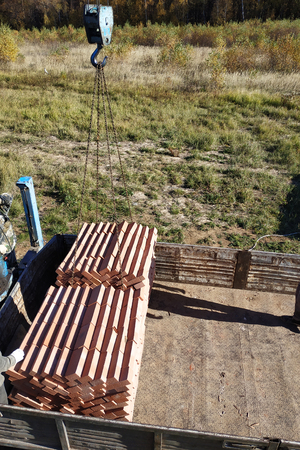 A truck crane unloads bricks for building a house 2018の写真素材