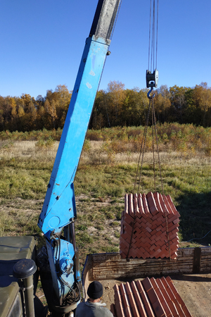 A truck crane unloads bricks for building a house 2018の写真素材
